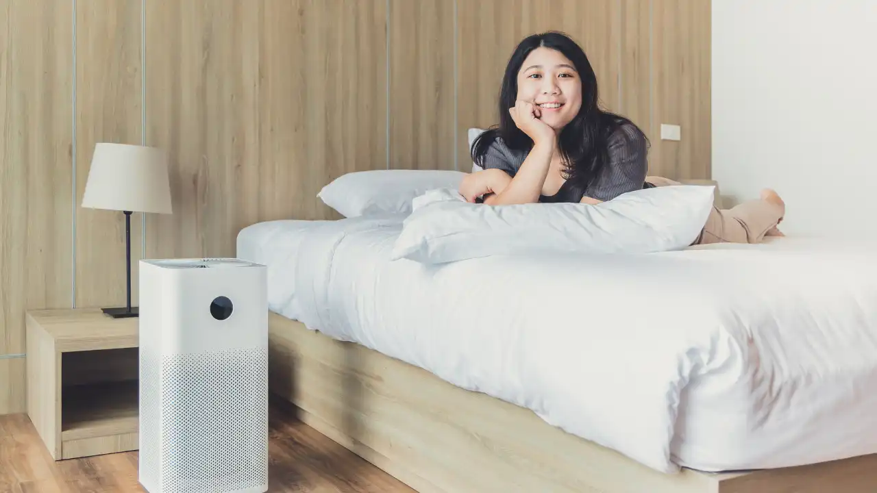 a girl smiling and feeling safe because of her Air Purifier
